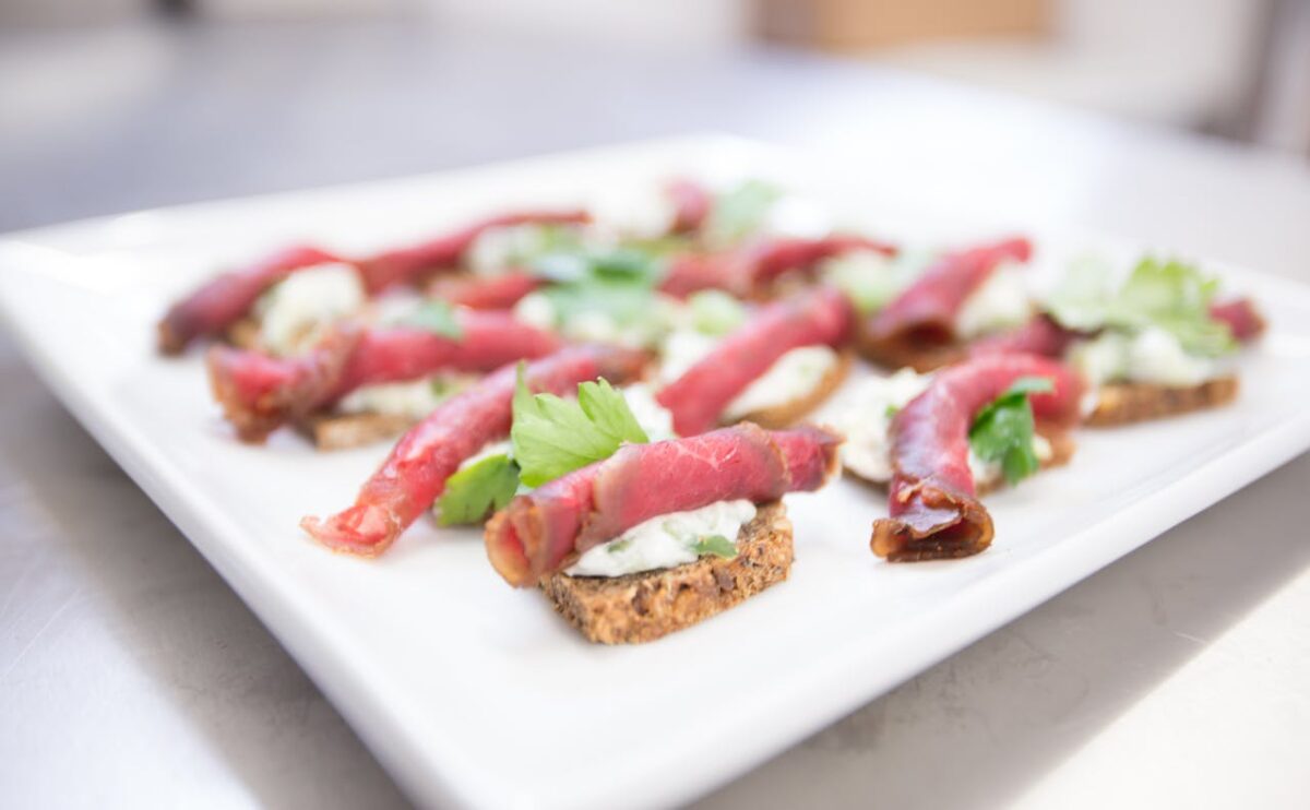 pexels photo Beef carpaccio with creamy spread on toasted bread garnished with herbs.