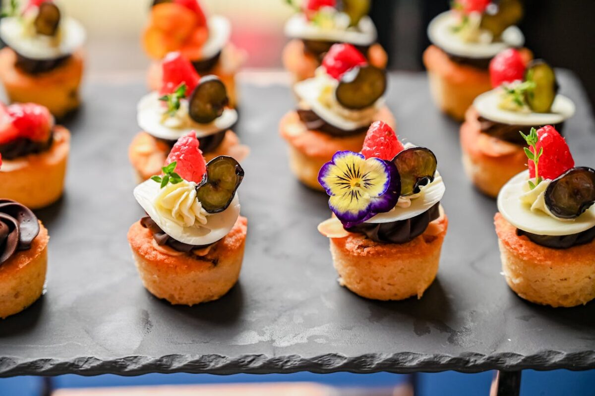 pexels photo 32121349 Delicious mini cupcakes topped with assorted fruits and flowers, perfect for elegant events.